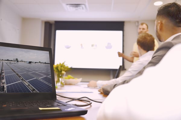 Laptop on boardroom table with image of Skyline Energy solar energy assets