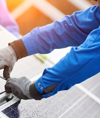 Worker installing a clean energy solar panel system Worker installing a clean energy solar panel system